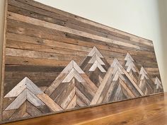 a wood paneled wall with an arrow pattern on it and a wooden shelf below