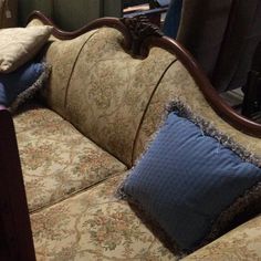 a couch with pillows on it in front of a window