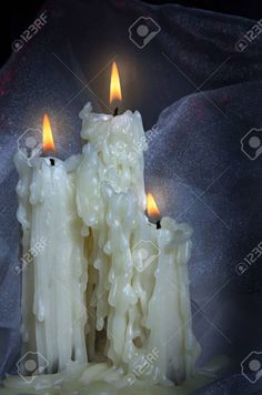 three candles are lit in the dark with white frosting on them stock photo - 789