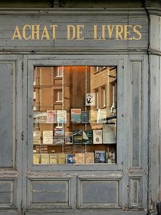 an old store front with lots of books in it's glass window and the words achat de livres