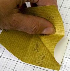 a person cutting out a piece of yellow paper