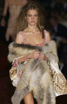 a model walks down the runway in a fur coat