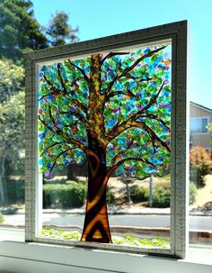 a window with a tree painted on the glass in it's center and bottom