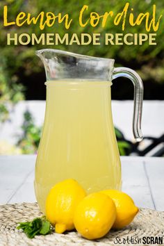 lemon cordial homemade recipe in a pitcher with three lemons on the table next to it