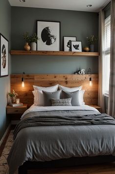 a bed sitting in a bedroom next to a window with two framed pictures on the wall