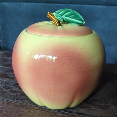 an apple shaped container sitting on top of a wooden table