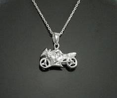 a silver necklace with a motorcycle on it