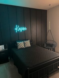 a bedroom with a black bed and neon lights on the wall above it, along with a hammock chair