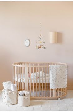 a baby crib in the corner of a room with pink walls and white rugs