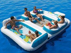 several people sitting in an inflatable raft floating on the blue water with two adults and one child