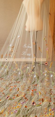 a wedding veil with flowers and leaves on it