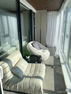 a living room filled with furniture next to large windows