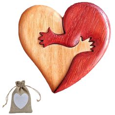 a wooden heart with a bird on it next to a bag