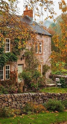 an old stone house surrounded by autumn foliage