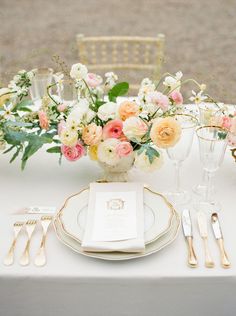 the table is set with flowers and gold cutlery for an elegant wedding reception or special event