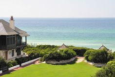 an aerial view of a house with the ocean in the background