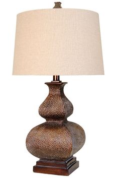 a lamp that is sitting on top of a wooden base with a white linen shade