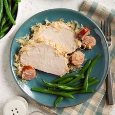 a blue plate topped with meat and green beans