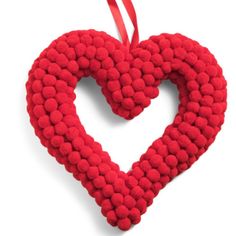 a red heart shaped ornament hanging from a ribbon