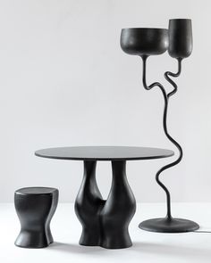 the table and two chairs are made out of black plastic, with one light on top