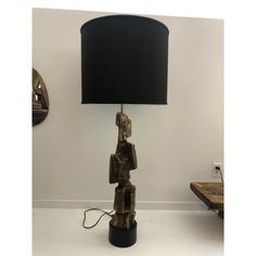 a lamp that is sitting on top of a table with a black shade over it