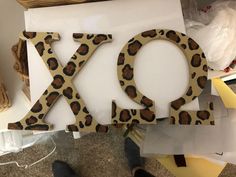 the word xo is made out of wood and has leopard print letters on it