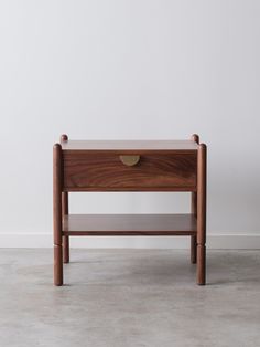 a small wooden table with two drawers on one side and an open drawer on the other