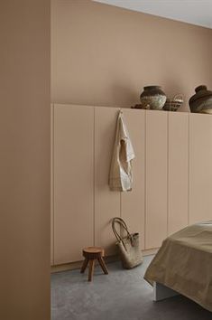 a bed sitting next to a wall with vases on top of it