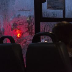 two seats in front of a frosted window with red light coming from behind it