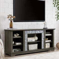 a flat screen tv sitting on top of a wooden entertainment center in a living room