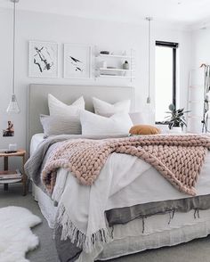 a bed with white sheets and blankets on top of it in a bedroom next to a window