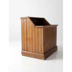 a wooden trash can sitting on top of a white floor