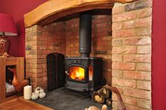 a wood burning stove sitting inside of a living room next to a red brick wall