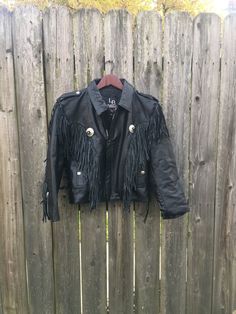 This is an incredible vintage leather jacket with some incredible fringe that is ready to make your life perfect. If you want to look amazing anywhere you go in life, get this now. It is in good condition but has a little wear on the shoulder strap, pictured. There is no other damage and the jacket has no rips, holes, stains or smells. Measurements: Pit to pit: 19 1/2 inches Collar to bottom front: 17 inches Collar to bottom back: 20 1/4 inches Sleeve Length (from collar): 25 inches Size on tag: Black Leather Outerwear With Fringe, Black Leather Fringe Outerwear, Fall Festival Leather Jacket With Fringe, Fall Biker Leather Jacket With Fringe, Winter Festival Leather Jacket With Fringe, Thumb Hole Shirts, Diy Jacket, Pretty Shorts, Lace Side