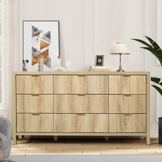 a large wooden dresser sitting in a living room next to a chair and potted plant