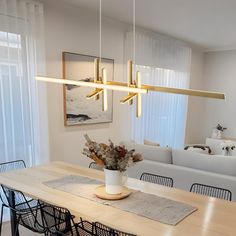 a dining room table with chairs and a vase filled with flowers