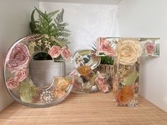 three vases filled with flowers sitting on top of a wooden table next to each other