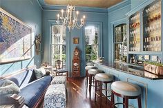 a living room filled with lots of furniture and a chandelier hanging from the ceiling