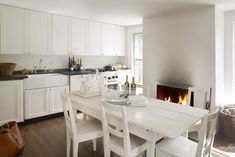 a kitchen with a table and chairs next to a fire place in the fireplace area