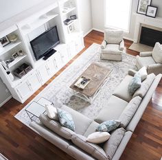 a living room filled with furniture and a flat screen tv on top of a wooden floor