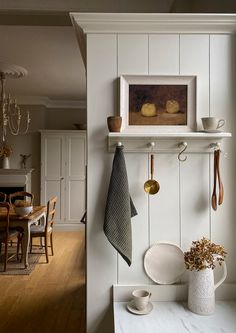 a kitchen with white walls and wooden floors