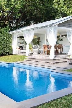 a pool with a gazebo next to it and some chairs around the pool area