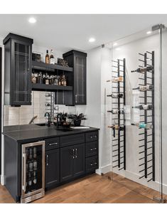 a kitchen with black cabinets and wine racks