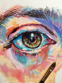 an eye is painted with colored pencils and watercolor on white paper, next to a brush