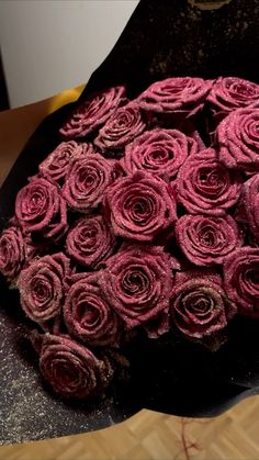 a bunch of rolled up pink roses sitting on top of a table