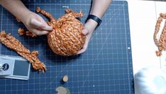 someone is crocheting an animal out of yarn on a cutting board with scissors