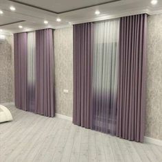 an empty room with purple curtains and white furniture