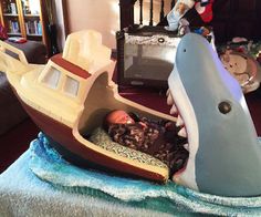 a baby laying in a boat shaped like a whale on top of a blue blanket