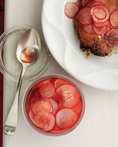 a white plate topped with meat next to a bowl of sliced up radishes