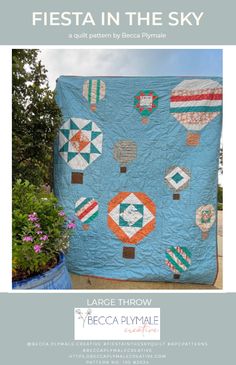 a blue quilt with hot air balloons on it and the words fiesta in the sky